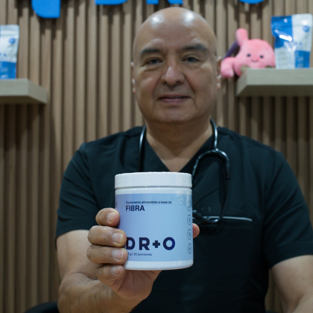 Dr. Olguín en su consultorio sosteniendo Fibra DR+O